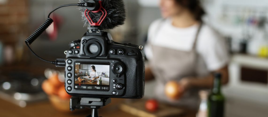 Female vlogger recording cooking related broadcast at home