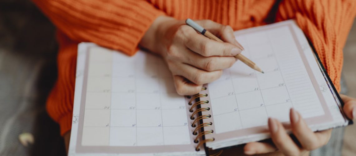 Woman writing on her daily planner